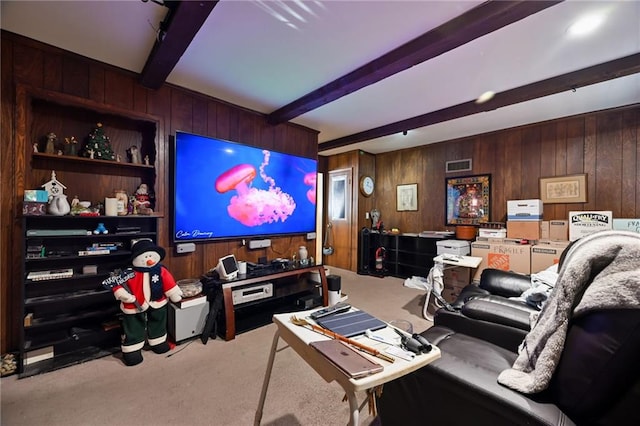 carpeted home theater room featuring beamed ceiling, visible vents, and wooden walls