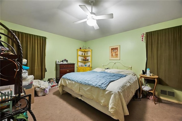 carpeted bedroom featuring a ceiling fan and visible vents