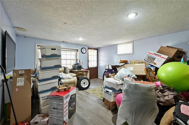 interior space with a textured ceiling and wood finished floors