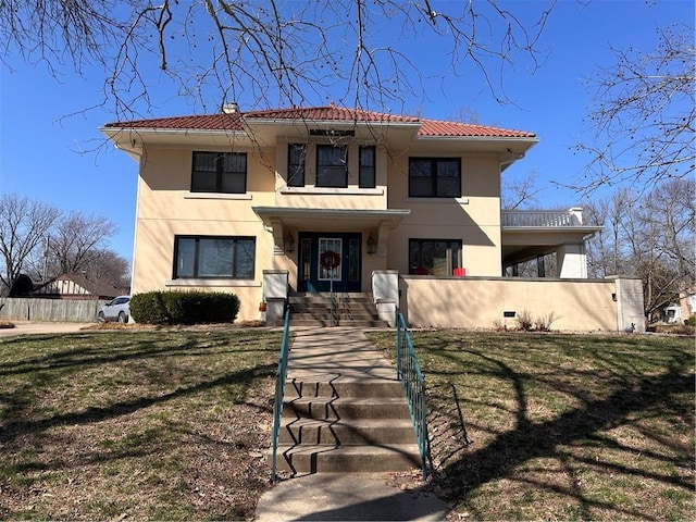 view of front of property featuring a front yard, a tiled roof, and stucco siding