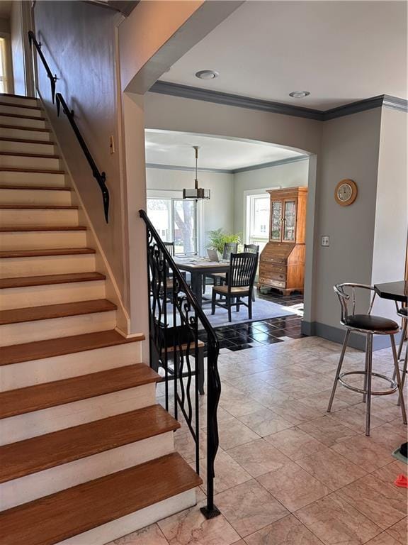 stairs featuring baseboards, arched walkways, and crown molding