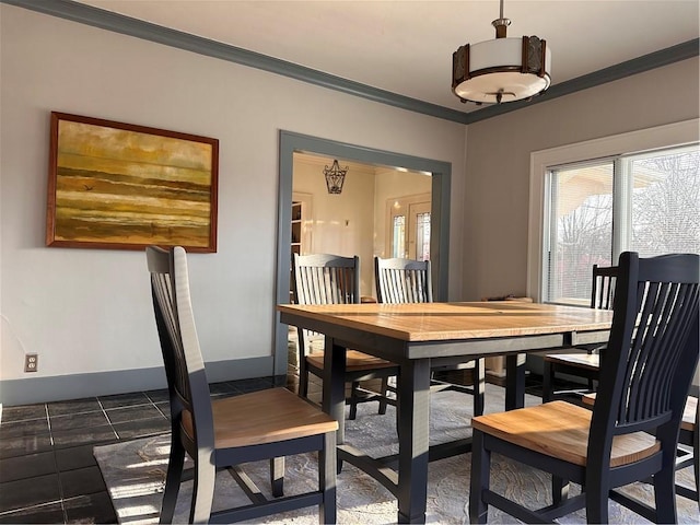 dining space featuring plenty of natural light, baseboards, and ornamental molding