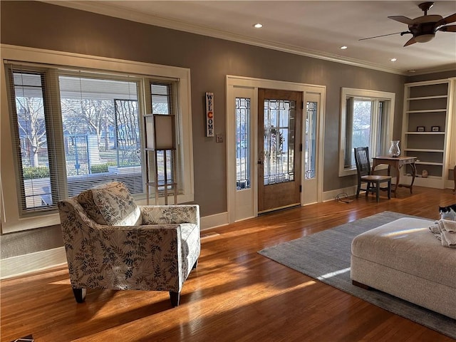 entryway featuring baseboards, wood finished floors, a ceiling fan, and ornamental molding