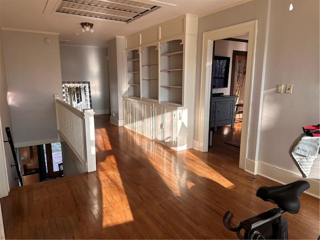 corridor featuring visible vents, crown molding, baseboards, an upstairs landing, and wood-type flooring