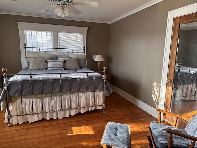 bedroom with ceiling fan, wood finished floors, baseboards, and ornamental molding