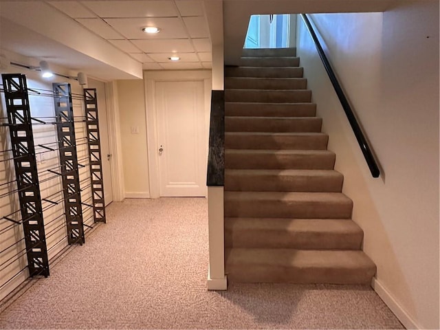 stairway featuring recessed lighting, a paneled ceiling, and baseboards