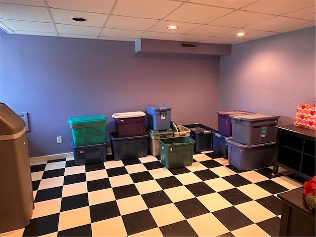 interior space with tile patterned floors, a paneled ceiling, visible vents, and baseboards