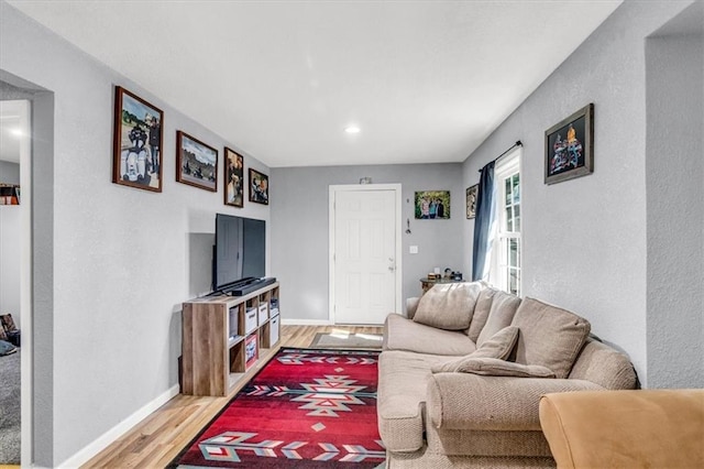 living area featuring baseboards and light wood-style floors