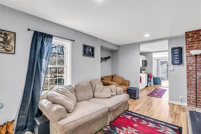 living area featuring light wood-style flooring and baseboards