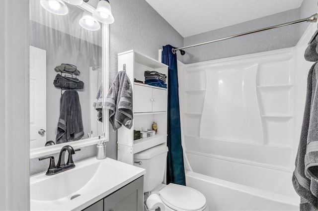 bathroom with shower / bathtub combination with curtain, toilet, vanity, and a textured wall