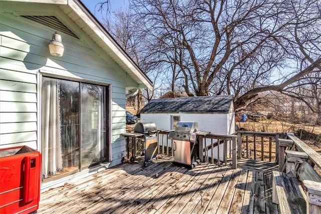 wooden deck with grilling area, a storage shed, and an outdoor structure