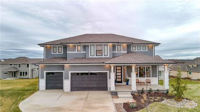 prairie-style house with a front lawn, a porch, concrete driveway, stucco siding, and an attached garage