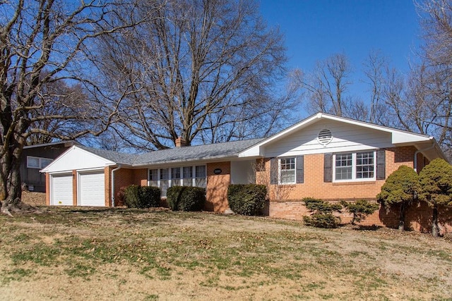 single story home featuring brick siding, a chimney, a front yard, and a garage