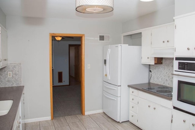 kitchen featuring white appliances, exhaust hood, visible vents, and backsplash