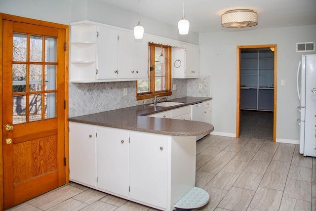 kitchen with white appliances, dark countertops, visible vents, and a sink