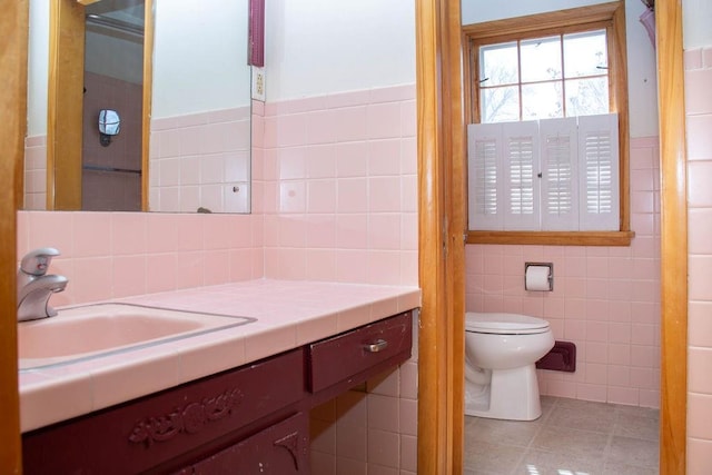 bathroom featuring vanity, tile walls, toilet, and tile patterned flooring