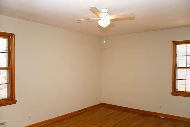 spare room featuring a ceiling fan, wood finished floors, and baseboards