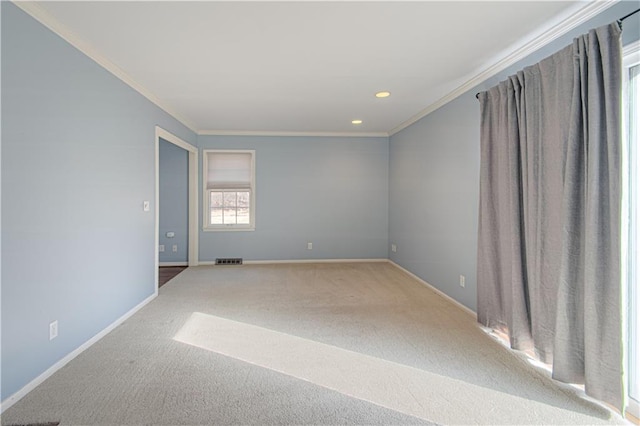 empty room with carpet flooring, crown molding, and visible vents