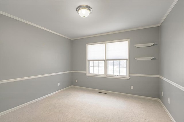 carpeted empty room with visible vents, crown molding, and baseboards