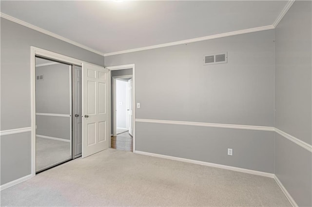 unfurnished bedroom with crown molding, baseboards, visible vents, and carpet floors