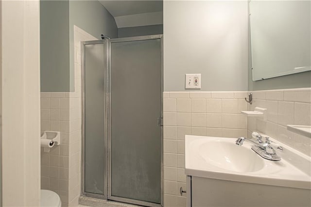 full bath with toilet, a stall shower, and tile walls