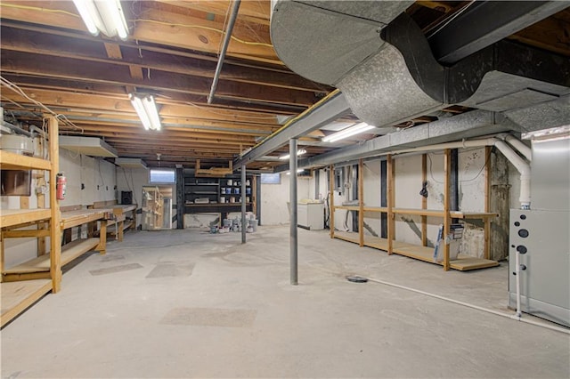 unfinished basement featuring a workshop area and washer / clothes dryer