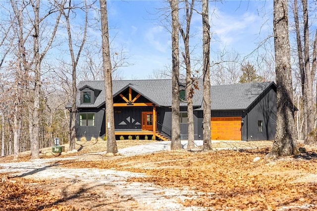 view of front of home featuring an attached garage, covered porch, board and batten siding, and a shingled roof