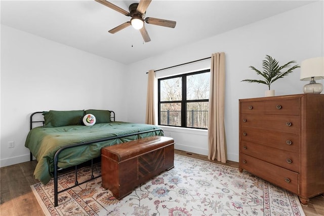 bedroom featuring a ceiling fan, light wood-style floors, and baseboards