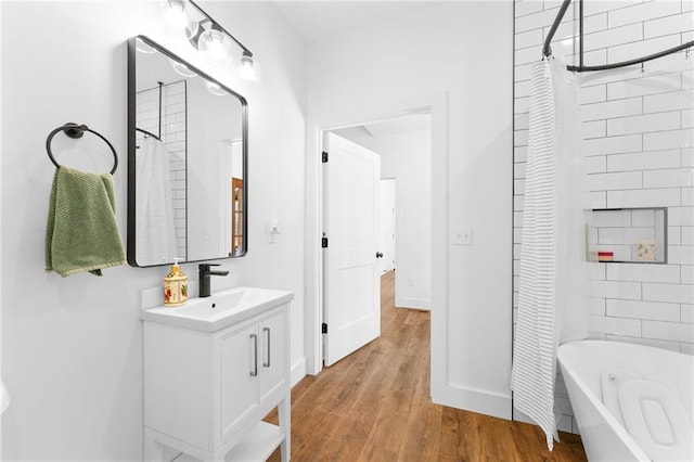 full bath with vanity, wood finished floors, and shower / bath combo with shower curtain