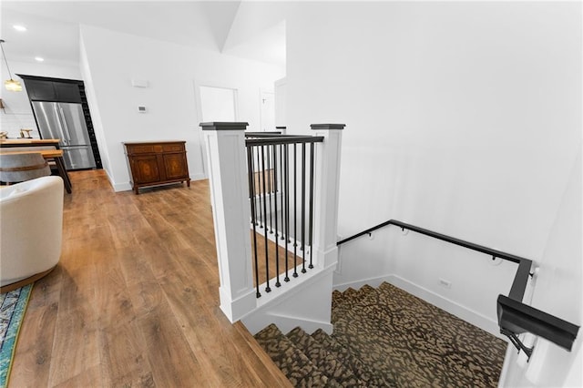 stairs with recessed lighting, wood finished floors, and baseboards