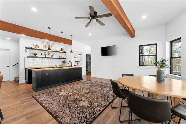 dining room with stairs, beamed ceiling, recessed lighting, and light wood-style floors