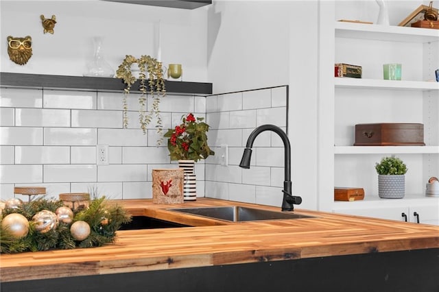 details featuring open shelves, tasteful backsplash, wooden counters, and a sink