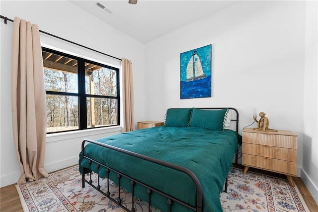 bedroom with visible vents, ceiling fan, baseboards, and wood finished floors