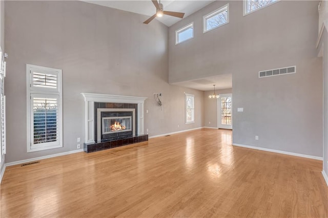 unfurnished living room featuring light wood-type flooring, visible vents, and a tile fireplace