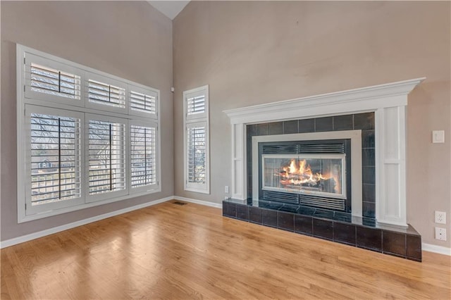 details featuring visible vents, baseboards, wood finished floors, and a fireplace