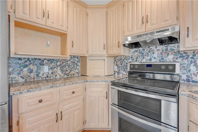 kitchen with light stone counters, open shelves, range with two ovens, under cabinet range hood, and tasteful backsplash