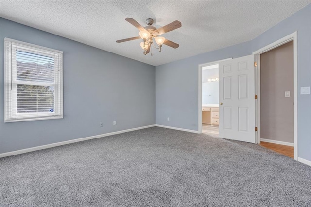 carpeted empty room featuring a textured ceiling, baseboards, and ceiling fan