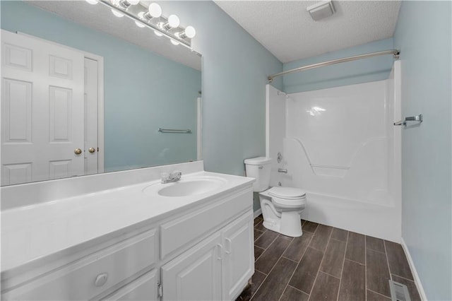 bathroom with vanity, visible vents, wood tiled floor, a textured ceiling, and toilet