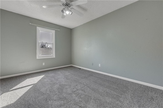 carpeted empty room featuring ceiling fan, baseboards, and a textured ceiling