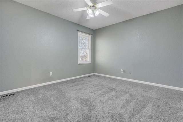 spare room featuring baseboards, carpet flooring, a textured wall, a textured ceiling, and a ceiling fan