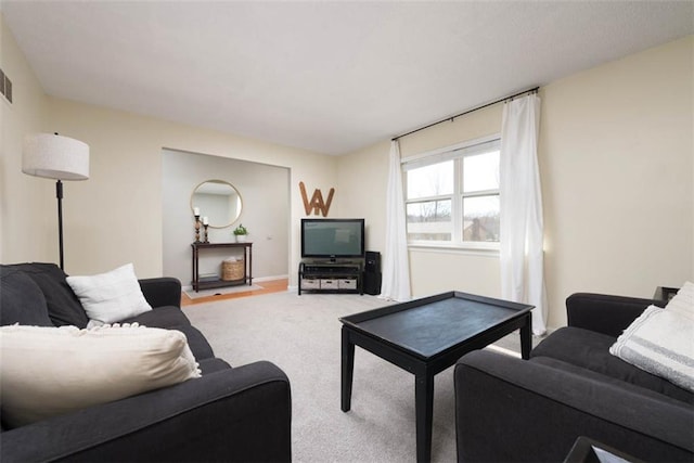 living room featuring visible vents, baseboards, and carpet