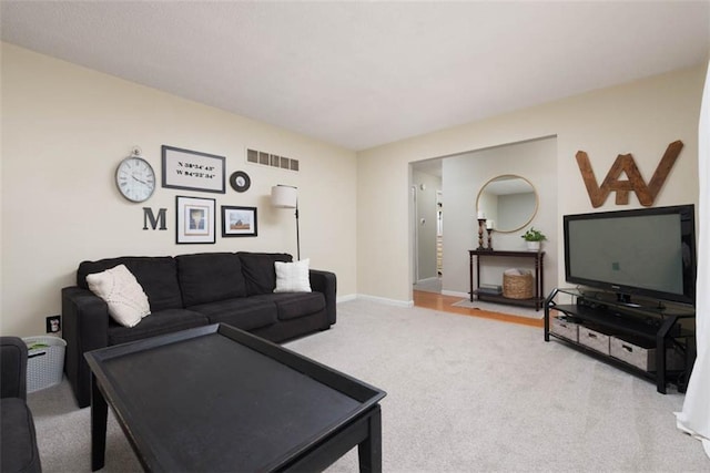 carpeted living area with visible vents and baseboards