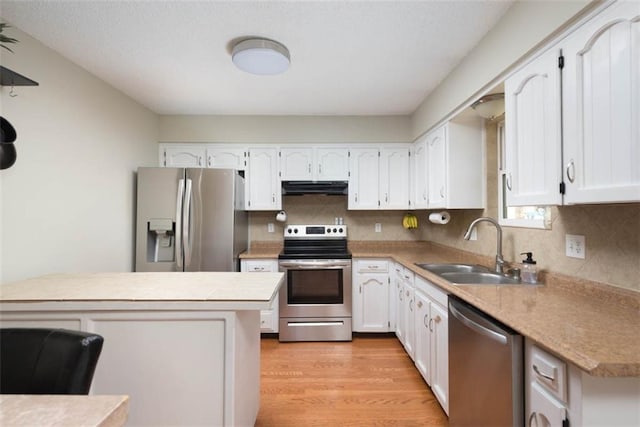 kitchen featuring under cabinet range hood, white cabinets, appliances with stainless steel finishes, and a sink