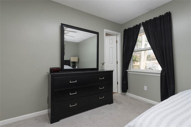 bedroom featuring light carpet and baseboards