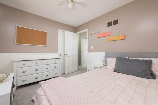 carpeted bedroom with visible vents and a ceiling fan