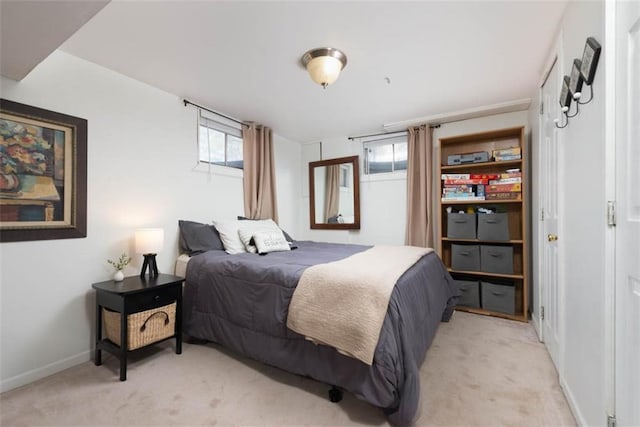 bedroom with light colored carpet and baseboards