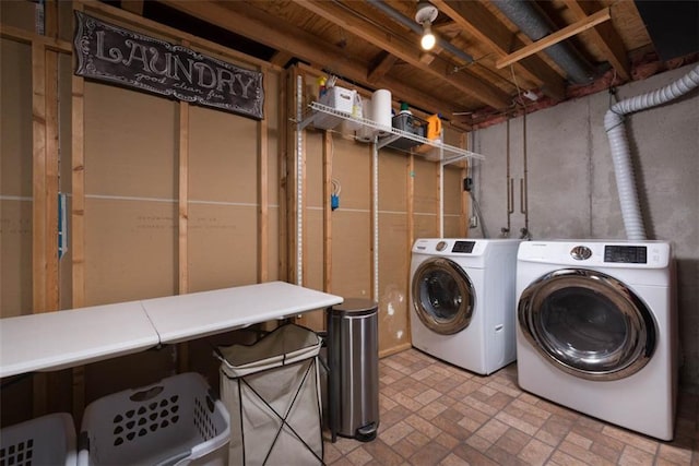 laundry area featuring brick floor and separate washer and dryer