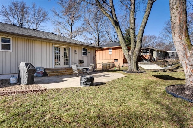 rear view of house featuring a yard, french doors, entry steps, and a patio