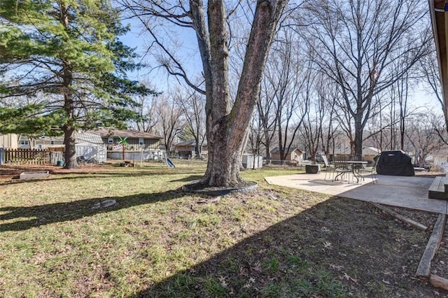 view of yard with an outdoor structure, playground community, a patio, and fence