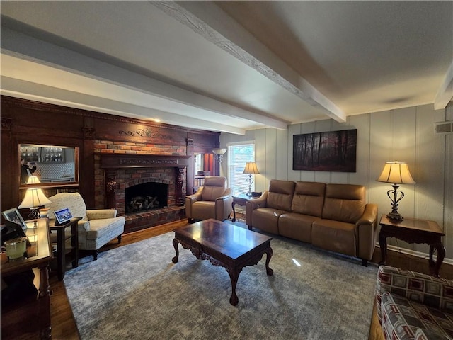 living room with beamed ceiling, a brick fireplace, and wood finished floors